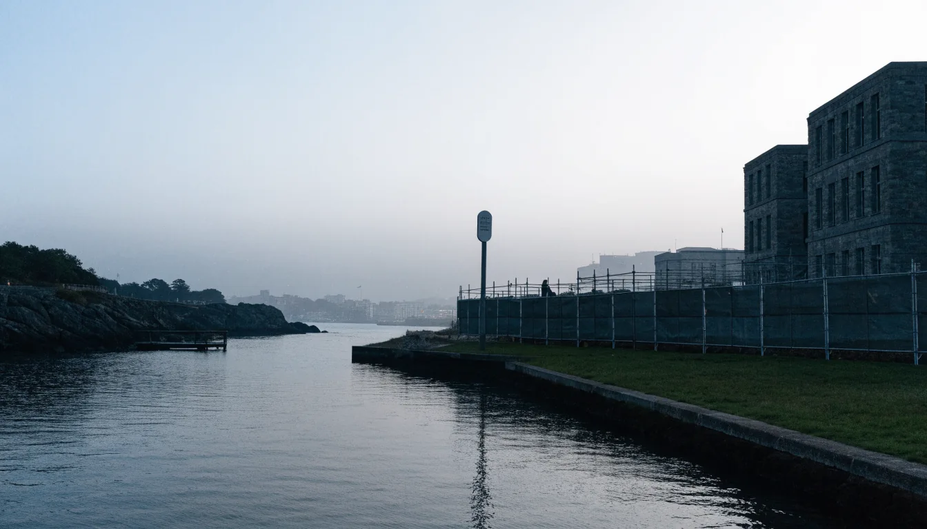 Dawn view of Wellington harbor with a stone building behind barriers.